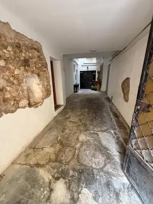 an empty hallway in a building with a stone wall at Appartement centre-ville Narbonne 5 personnes, climatisé, 2 chambres in Narbonne