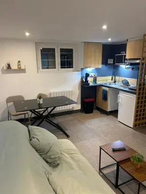 a living room with a couch and a kitchen at Chambre Studio B&B in Mazamet