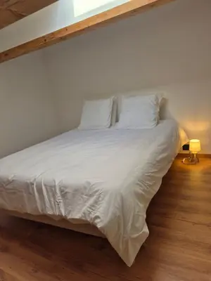 a bedroom with a bed with white sheets and pillows at Le Gîte du Parc in Roubia