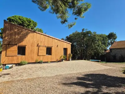 a barn with a gravel driveway in front of it at Le Gîte du Parc in Roubia