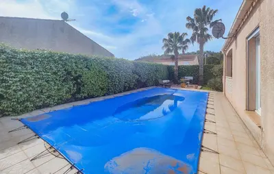 a blue swimming pool in the backyard of a house at Nice Home In Cessenon Sur Orb - Flh677 in Cessenon