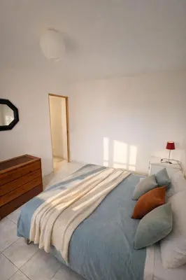 a bedroom with a large bed with pillows at Spacieux appartement Coeur du Village Wifi Draps in Gruissan