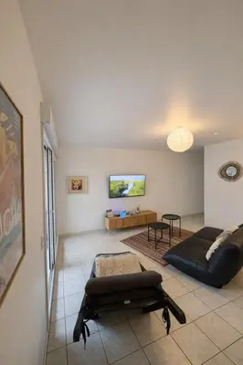 a living room with a couch and a table at Spacieux appartement Coeur du Village Wifi Draps in Gruissan