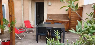 a black table and chairs on a patio at Apartment with large terrace, ground floor in Narbonne