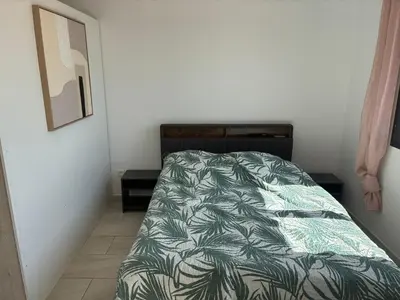 a bedroom with a bed with a green comforter at villa de vacances in Cessenon