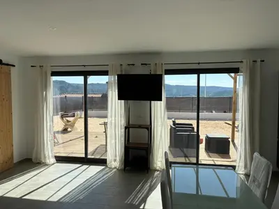 a living room with sliding glass doors and a flat screen tv at villa de vacances in Cessenon
