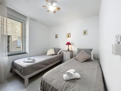two beds in a white room with a window at Le Rousseau - Comfortable apartment - Wi-Fi in Salles-d'Aude