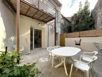 a white table and chairs on a patio at Le Rousseau - Comfortable apartment - Wi-Fi in Salles-d'Aude
