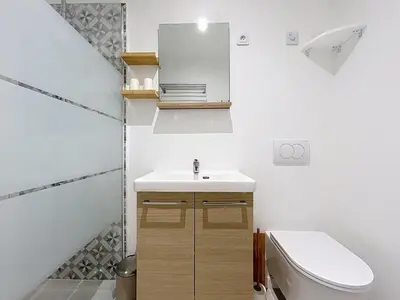 a bathroom with a sink and a toilet and a mirror at Le Rousseau - Comfortable apartment - Wi-Fi in Salles-d'Aude