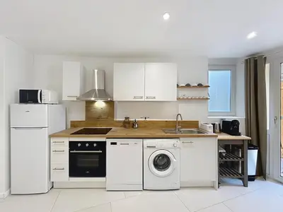 a kitchen with white appliances and a stove top oven at Le Rousseau - Comfortable apartment - Wi-Fi in Salles-d'Aude