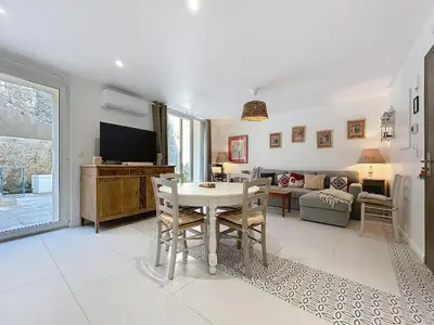 a living room with a table and a couch at Le Rousseau - Comfortable apartment - Wi-Fi in Salles-d'Aude
