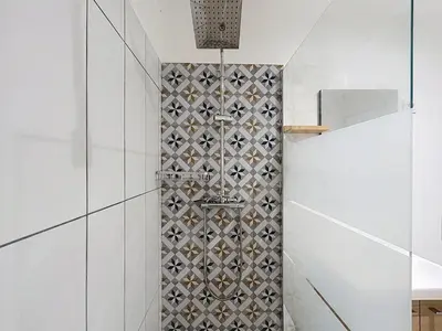 a bathroom with a shower with a tile wall at Le Rousseau - Comfortable apartment - Wi-Fi in Salles-d'Aude