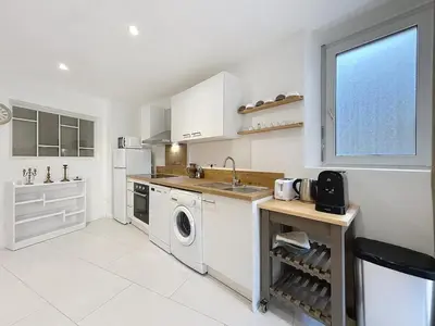 a white kitchen with a sink and a dishwasher at Le Rousseau - Comfortable apartment - Wi-Fi in Salles-d'Aude