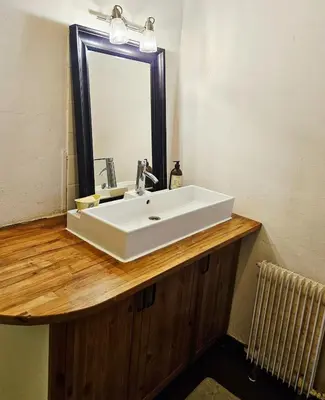a bathroom with a white sink and a mirror at Maison de vacances en Ariège in La Bastide-de-Bousignac