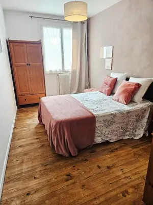 a bedroom with a bed with red pillows on it at Maison de vacances en Ariège in La Bastide-de-Bousignac