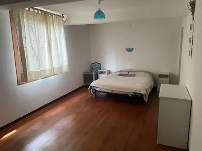 a bedroom with a bed and a wooden floor at Beautiful large country house 4 bedrooms in Teyssode