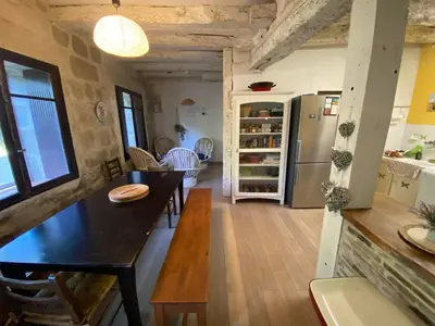 a kitchen and living room with a table and a refrigerator at Beautiful large country house 4 bedrooms in Teyssode