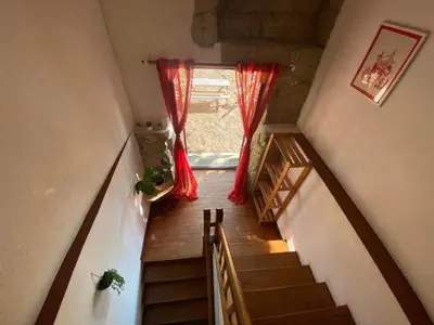 a staircase with red curtains and a window at Beautiful large country house 4 bedrooms in Teyssode