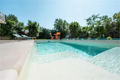 a swimming pool with blue water at Ambiance sudiste , piscine, boule, farniente AG in Carcassonne