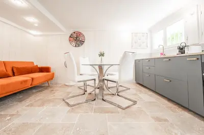a kitchen and living room with a table and chairs at Ambiance sudiste , piscine, boule, farniente AG in Carcassonne