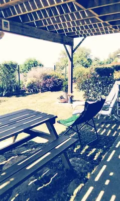 a picnic table and a chair under a pavilion at Chez Rosa in Pradelles-Cabardès
