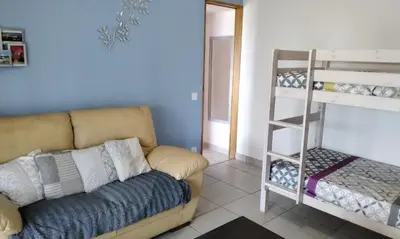 a living room with a couch and a bunk bed at Chez Rosa in Pradelles-Cabardès