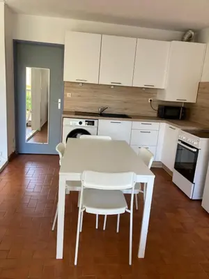 a kitchen with a white table and white chairs at Grand T2 à Gruissan, calme, vue sur le port in Gruissan