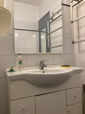 a bathroom with a sink and a mirror at Grand T2 à Gruissan, calme, vue sur le port in Gruissan
