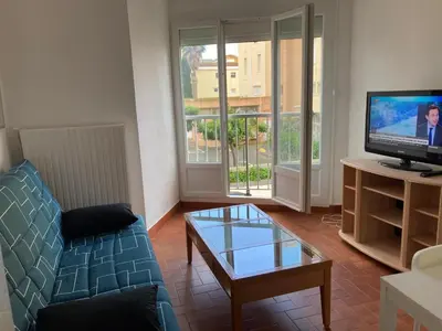 a living room with a couch and a tv at Grand T2 à Gruissan, calme, vue sur le port in Gruissan