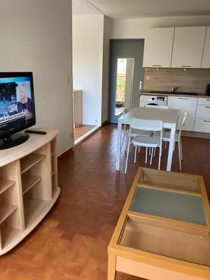 a living room with a table and a dining room at Grand T2 à Gruissan, calme, vue sur le port in Gruissan