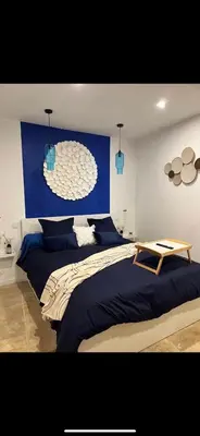 a bedroom with two beds and a blue wall at Apparemment Résidence la palmeraie in Lapalme