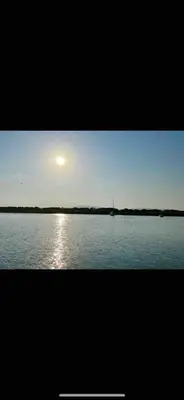 a view of the sun setting over a large body of water at Apparemment Résidence la palmeraie in Lapalme
