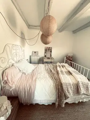 a bedroom with a bed with a white comforter at Maison de charme in Fontrieu
