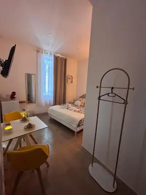 a bed with a brown headboard in a bedroom at La Perle in Narbonne