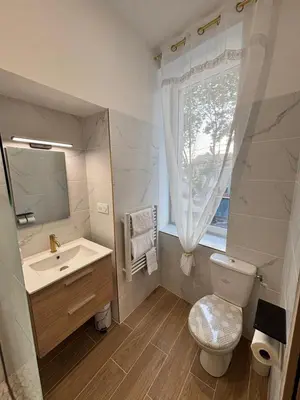 a bathroom with a sink and a toilet and a window at La Perle in Narbonne