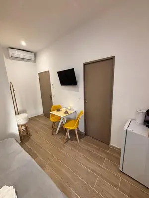 a bedroom with two beds and a table with chairs at La Perle in Narbonne