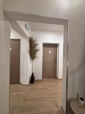an empty hallway with white walls and wood floors at La Jade in Narbonne