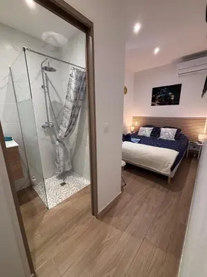 a bedroom with a bed and a table and a window at La Topaze in Narbonne