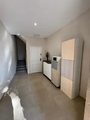 a kitchen with a refrigerator and a staircase at La Topaze in Narbonne