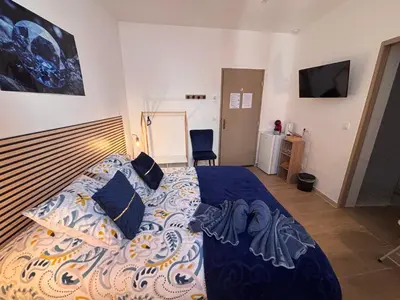 a bedroom with a bed with a blue comforter at La Saphir in Narbonne