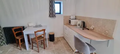 a kitchen with a counter and a table and chairs at La Métairie du Château, Elie in Aussillon