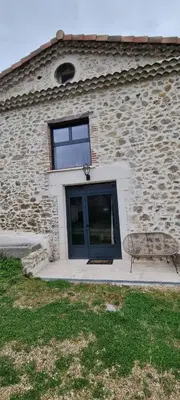 a building with a window and a bench in front of it at La Métairie du Château, Elie in Aussillon