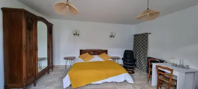 a bedroom with a bed with a yellow blanket on it at La Métairie du Château, Elie in Aussillon