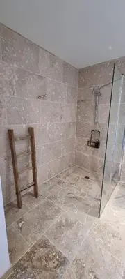 a bathroom with a shower with a glass door at La Métairie du Château, Elie in Aussillon