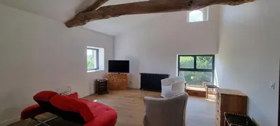 a living room with a red couch and chairs at Métairie du Château Berthe in Aussillon