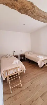 a bedroom with two beds and a wooden floor at Métairie du Château Berthe in Aussillon