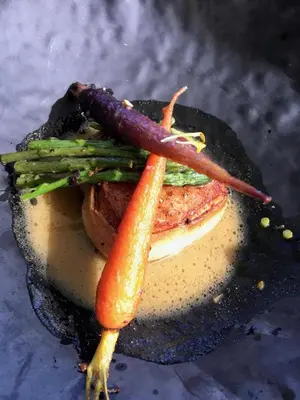 a sandwich with carrots and meat on a plate at Villa Et au milieu coule un ruisseau - Piscine, jacuzzi privé, boulodrome in Berlou