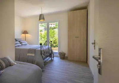 a bed with two pillows and a red lamp at Villa Et au milieu coule un ruisseau - Piscine, jacuzzi privé, boulodrome in Berlou