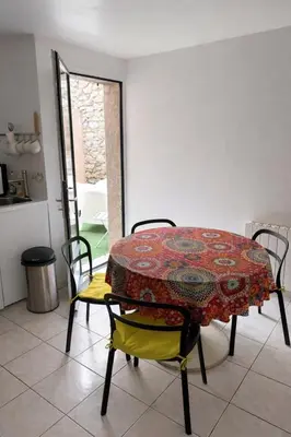 a table and chairs in a room with a window at Au cœur du village de Gruissan in Gruissan
