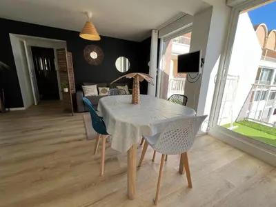 a dining room with a table and chairs at Bel appartement avec piscine et vue bateaux in Gruissan